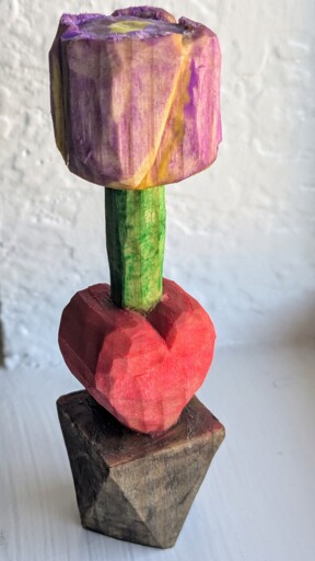 A carving of a purple tulip with a heart